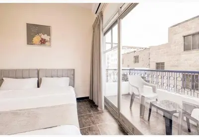 a bedroom with a bed and a balcony with a table and chairs at Magic Waves Hotel Aqaba in Aqaba