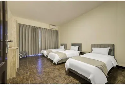 a hotel room with two beds and a window at Magic Waves Hotel Aqaba in Aqaba