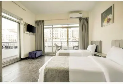 a hotel room with two beds and a large window at Magic Waves Hotel Aqaba in Aqaba