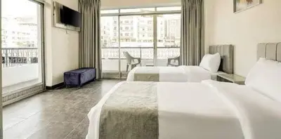 a hotel room with two beds and a balcony at Magic Waves Hotel Aqaba in Aqaba