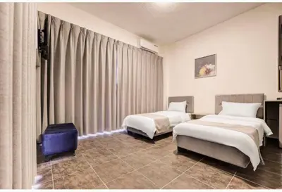 a hotel room with two beds and a large window at Magic Waves Hotel Aqaba in Aqaba