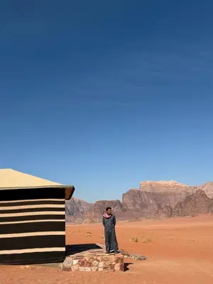 a man standing next to a building in the desert at Milky Way Wadi Rum in Wadi Rum