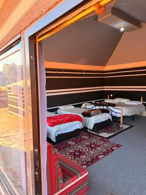 a group of beds in a room with a window at Milky Way Wadi Rum in Wadi Rum