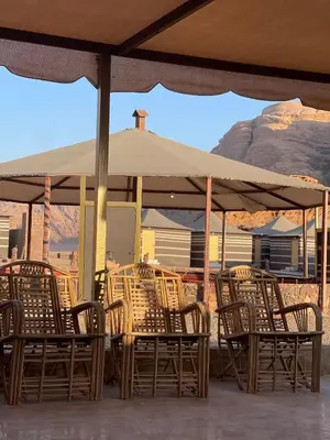 a group of tables and chairs under an umbrella at Princess Camp in Wadi Rum