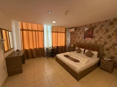 a bedroom with a bed and a desk and a table at El RAYYAN HOTEL SUITES in Amman
