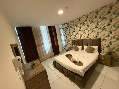 a bedroom with a bed in a room with a wall at El RAYYAN HOTEL SUITES in Amman