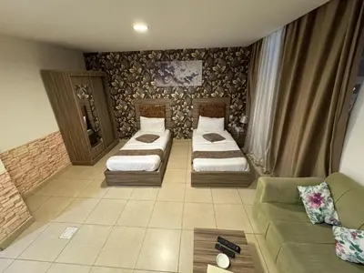 a living room with two beds and a couch at El RAYYAN HOTEL SUITES in Amman
