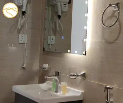 a bathroom with a sink and a mirror at Amber Luxury Camp in Maḩaţţat Dīsah