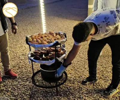 a man bending over to look at a basket of potatoes at Amber Luxury Camp in Maḩaţţat Dīsah