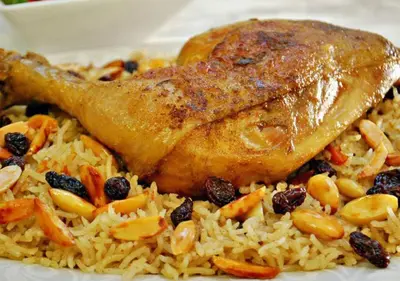 a plate of rice with a piece of chicken on top at Desert Waves Camp in Wadi Rum