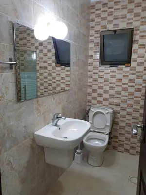 a bathroom with a sink and a toilet and a tv at Waleed's Studio in Amman