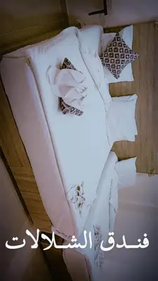 a bed with white sheets and ties on it at فندق الشلالات العقبه Waterfalls Hotel Aqaba in Aqaba