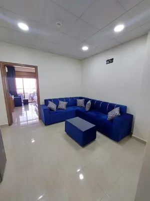 a living room with a blue couch and a table at فندق الشلالات العقبه Waterfalls Hotel Aqaba in Aqaba