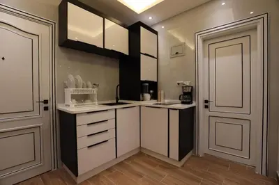 a large kitchen with white cabinets and a door at A luxurious apartment for relaxation in Amman in Amman