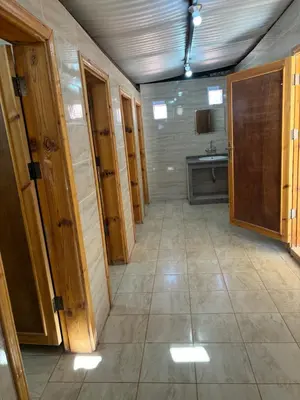a large bathroom with wooden doors and a tile floor at Panorama Wadi Rum Sunset Camp in Wadi Rum