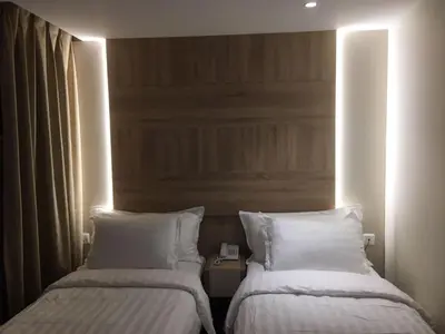 two beds in a hotel room with white pillows at Aysel Hotel in Aqaba