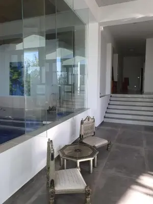 a room with two benches and a glass wall at One-of-Kind home - city & nature in Amman