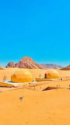 two domes in the desert with mountains in the background at MARS MIRROR BUBBLE lUXURY CAMP in Wadi Rum