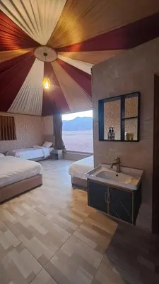 a bathroom with two beds and a sink in a room at Wadi Rum Jeep Tour Sleeping under the stars in Wadi Rum
