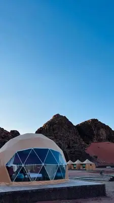 a tent in the desert with mountains in the background at Wadi Rum Jeep Tour Sleeping under the stars in Wadi Rum