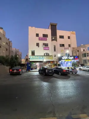 a parking lot with cars parked in front of a building at Osama Alnaser in Amman