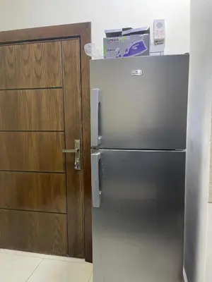 a stainless steel refrigerator next to a wooden door at Osama Alnaser in Amman