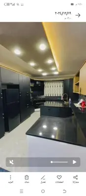 a kitchen with black cabinets and a counter top at اربد طريق البترول دبج مول فيلا مزرعة مفروشة للايجار يومي أسبوعي شهري in Juḩfīyah