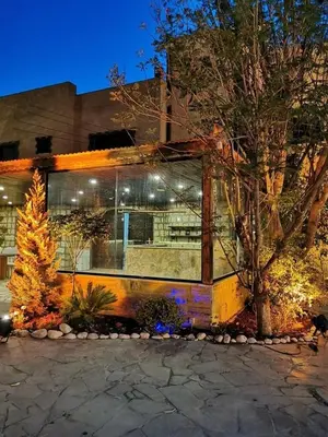 a building with a tree in front of it at Qastal Zaman in Amman