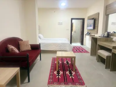 a room with a bed and a couch and a chair at Qastal Zaman in Amman
