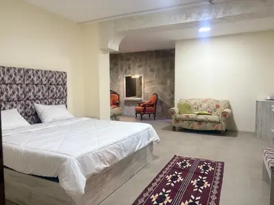 a bedroom with a bed and a couch and a chair at Qastal Zaman in Amman