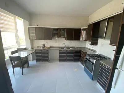 a kitchen with a sink and a stove top oven at Bright & Spacious, Upscale Amman in Amman