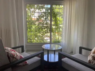 a living room with a table and a window at Bright & Spacious, Upscale Amman in Amman