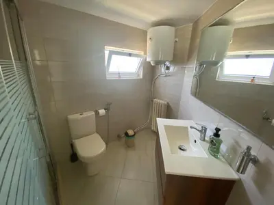 a bathroom with a toilet and a sink and a shower at Bright & Spacious, Upscale Amman in Amman