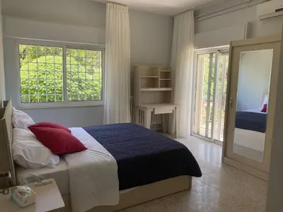 a bedroom with a bed with red pillows and a mirror at Bright & Spacious, Upscale Amman in Amman