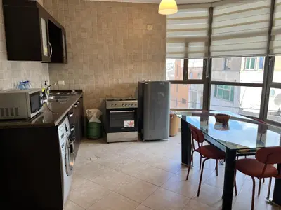 a kitchen with a counter and a table and appliances at Modern, fully equipped apartment in Jabal Amman in Amman