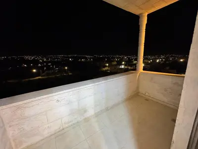a room with a view of a city at night at شقه مفروشه حديثة ذات أطلالة جميلة ومكان هادئ in Irbid