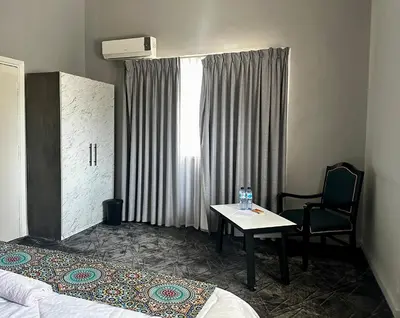 a hotel room with a table and a chair and a window at Beit Ahlan in Amman