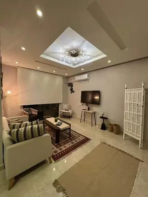 a living room with a couch and a flat screen tv at The Elysium in Amman