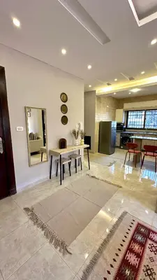 a living room with a table and a mirror at The Elysium in Amman