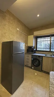 a kitchen with a stainless steel refrigerator and a dishwasher at The Elysium in Amman