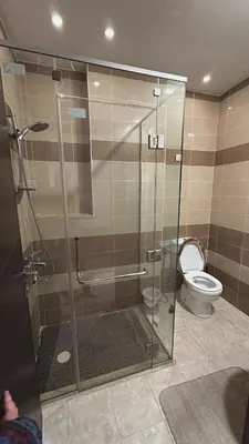 a bathroom with a glass shower with a toilet at The Elysium in Amman
