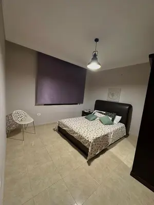 a bedroom with a bed and a table and a chair at The Elysium in Amman
