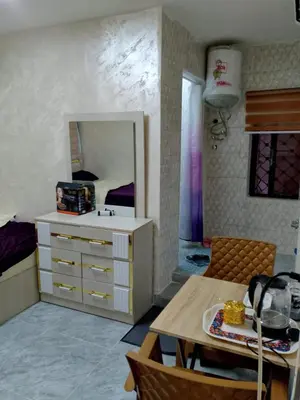 a living room with a table and a bedroom at Ahmad Hostel in Kerak
