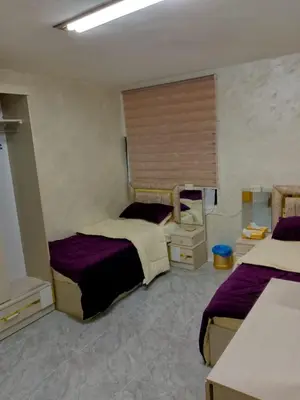 a bedroom with two beds and a window at Ahmad Hostel in Kerak