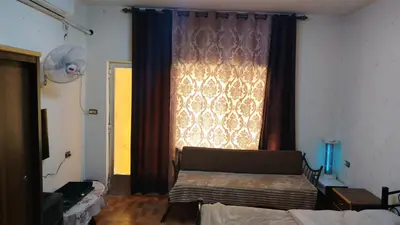a living room with a couch and a large window at stone house in Amman