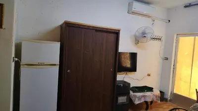 a room with a wooden door and a refrigerator at stone house in Amman