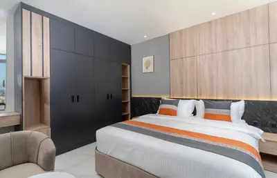 a bedroom with a large bed and a chair at Diamond Palm Hotel & Resort in Al Burj