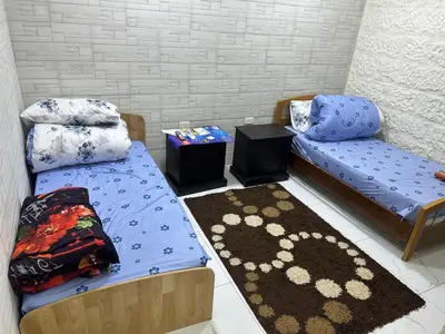 a room with two twin beds and a rug at عمان in Amman