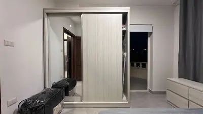 a bedroom with a mirror and a couch in a room at One bedroom near University of Jordan in Amman