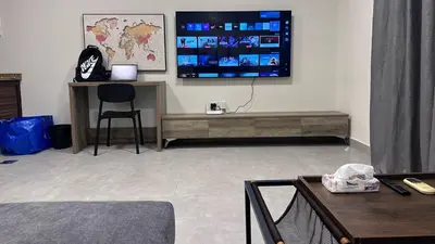 a living room with a tv on a wall at One bedroom near University of Jordan in Amman